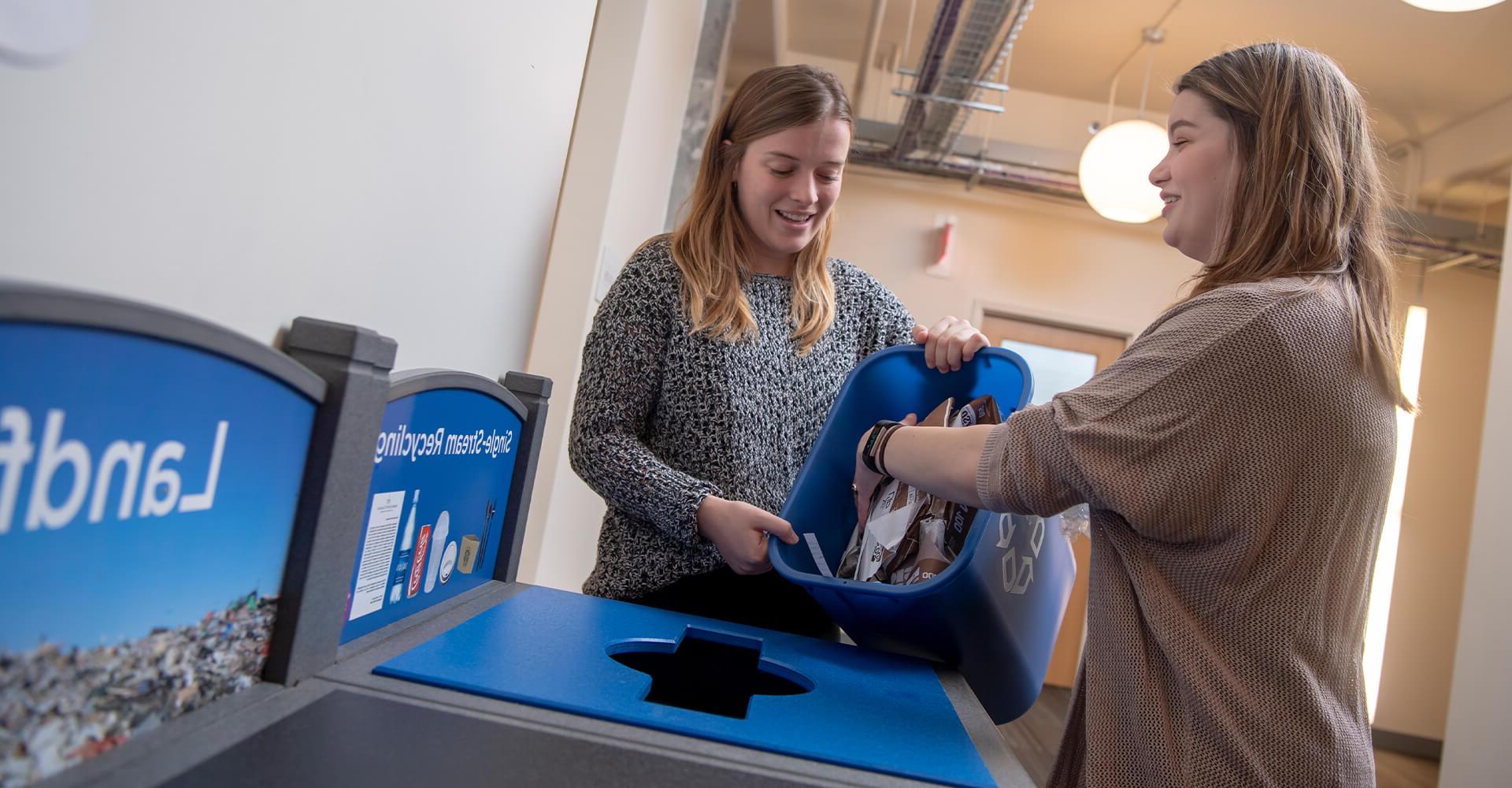 two students recycling paper